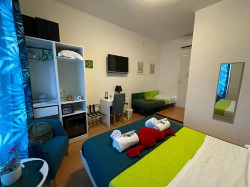 Camera Verde presso AD Trastevere Guest House a Roma con biancheria verde lime, area studio e arredi moderni