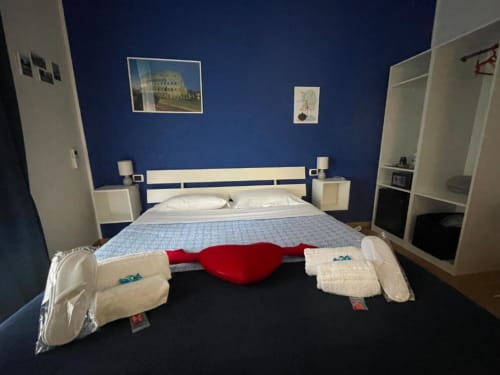 Camera blu della AD Trastevere Guest House a Roma con letto, comodini bianchi e articoli da toilette esposti