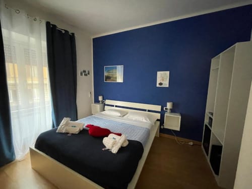 Camera Blu presso AD Trastevere Guest House a Roma con letto matrimoniale, mobili color crema e vista sulla città