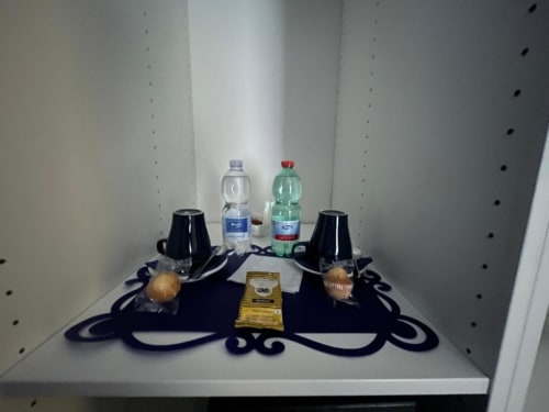 Vassoio di benvenuto nella Blue Room dell'AD Trastevere Guest House con bottiglie d'acqua, dolcetti e tazze a Roma
