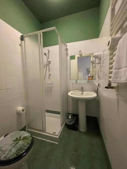 Bagno moderno della Green Room ad AD Trastevere Guest House, Roma con doccia, lavabo su piedistallo e pareti verde accento