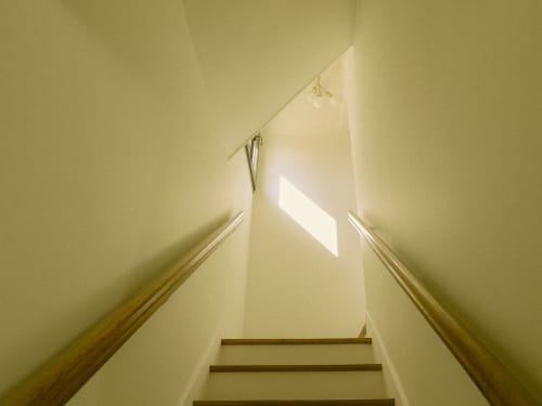 Escalier aux rampes en bois menant vers la lumière naturelle à La Guirtelle B&B à Lainsecq, France