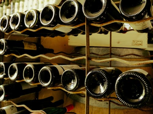 Wine bottles stored on wooden racks at La Guirtelle B&B in Lainsecq, France