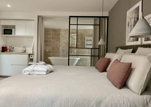 Bright bedroom with glass partition and lounge – Lodge Bernadette