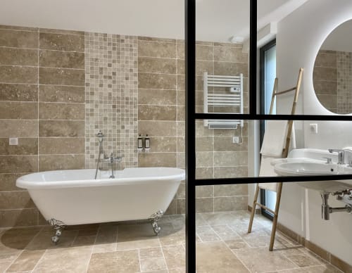 Bathroom with designer bathtub and beige tiles