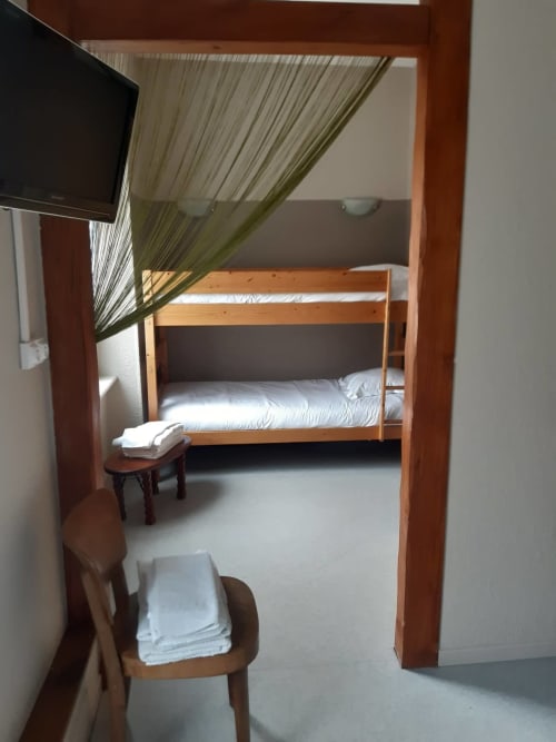 Chambre cosy à la Résidence Soansa du Gerardmer avec lits superposés, mobilier en bois et TV à Soultzeren