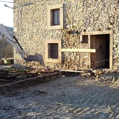 Entrada de Apartamentos Casa Lafuente en Lukiano, Araba. Edificio de piedra con fachada crema y puertas de madera.