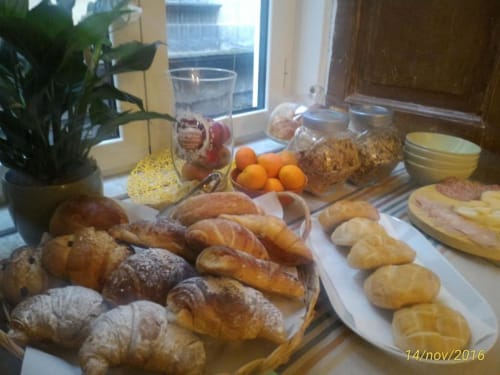 Desayuno continental en el B&B Il Conservatorio de Nápoles con pasteles frescos, pan, croissants y frutas cítricas