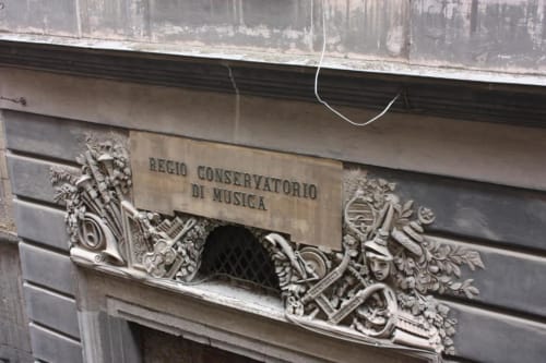 Ornate stone plaque reading 'Regio Conservatorio di Musica' at B&B Il Conservatorio entrance in Naples