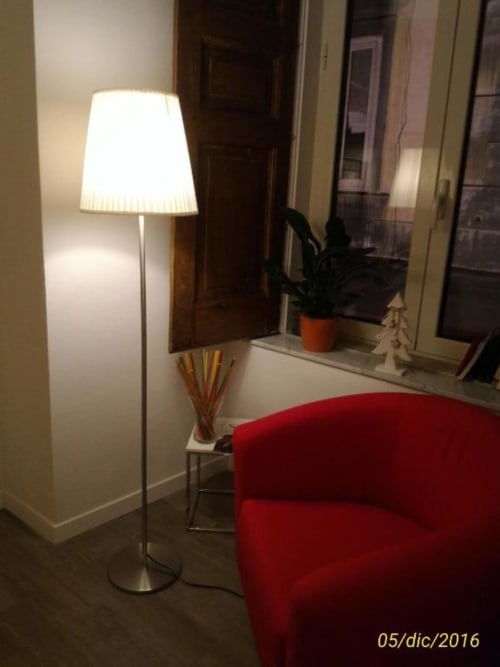 Modern floor lamp with white shade next to red armchair in B&B Il Conservatorio guest room, Naples