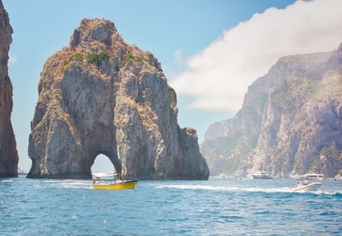 Iconic Capri arch with colorful boat, Napoli coastal escape