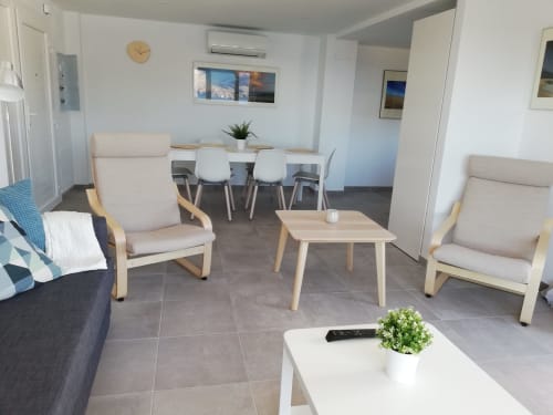 Sala de estar moderna en El Faro De Los Genoveses con cómodos muebles, mesa de comedor y vistas al mar en San José