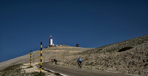 Cyclists on mountain road with lighthouse, Grignan region near Le Pavillon M