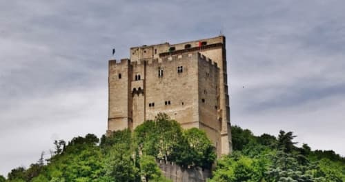 Medieval castle tower surrounded by lush greenery in Grignan, France, near Le Pavillon M guesthouse