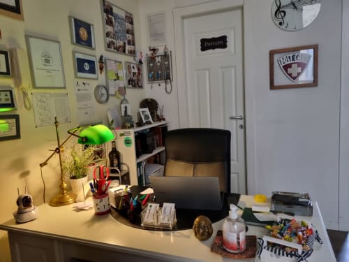 Office workspace at B&B Il Conservatorio Naples with desk, laptop, plants, and musical decor