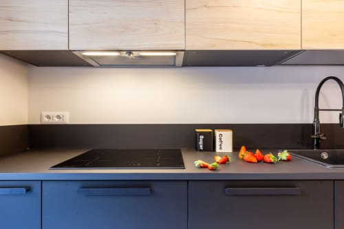 Cucina moderna di Casa Lounge Istria a Cagliari con mobili blu, piano nero, piano cottura a induzione e fresco