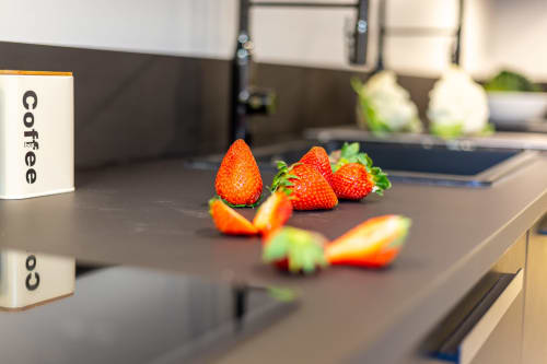 Fragole fresche sul bancone scuro della cucina di Casa Lounge Istria, Cagliari