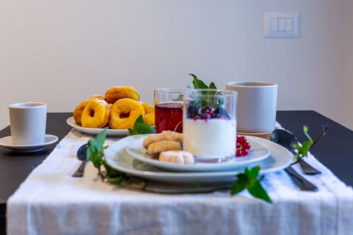 Elegante tavolo colazione a Casa Lounge Istria a Cagliari con donuts, pasticcini, succo e servizio caffè