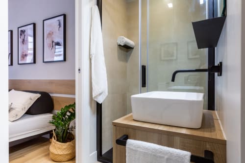 Bagno moderno di Casa Lounge Istria, Cagliari con lavabo bianco, rubinetteria nera e box doccia in vetro