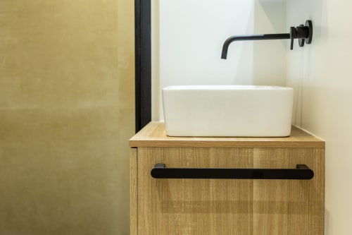 Lavabo in ceramica bianca con mobile in legno e rubinetto nero a parete presso Casa Lounge Istria, Cagliari