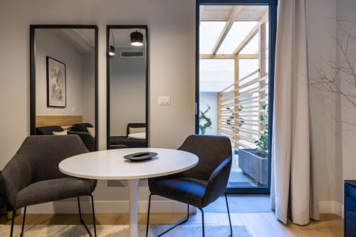 Suite moderna di Casa Lounge Istria, Cagliari con tavolo rotondo bianco, sedie scure e accesso al balcone