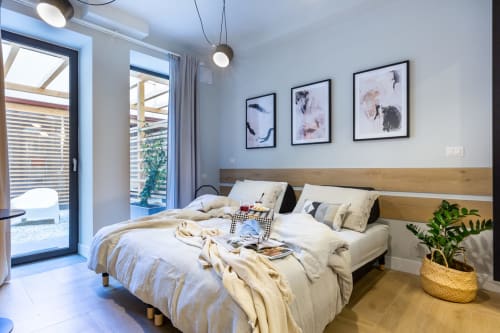 Camera moderna a Casa Lounge Istria con vista giardino, testata in legno, biancheria neutra, lampade a sospensione e arte incorniciata