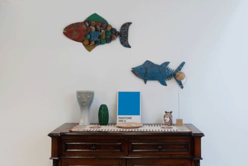 Articoli decorativi artigianali e colorati pesci su comò in legno presso le Camere Sicilianinsta a Catania