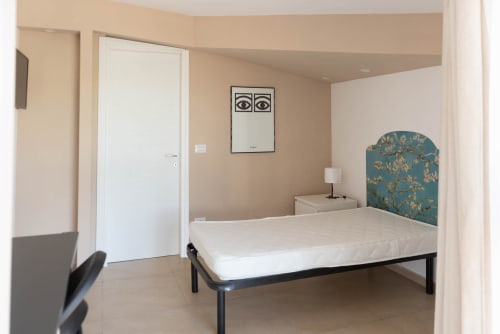 Camera moderna a Sicilianinsta Rooms a Catania con letto bianco, testiera turchese e arredamento minimalista