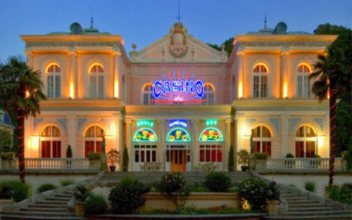 Bâtiment de casino illuminé à l'architecture néoclassique à Vernet-les-Bains, France au crépuscule