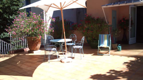 Terrasse ensoleillée aux Chambres D'hôtes Les2lions à Vernet-les-Bains avec parasol, mobilier et plantes fleuries