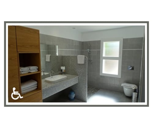 Salle de bains accessible à la Résidence Saint Michel B&B à L'île Rousse avec carrelage gris moderne, lavabo, douche, toilettes