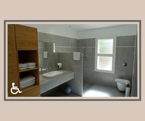 Salle de bain accessible à la Résidence Saint Michel B&B à L'Île-Rousse, design moderne, douche, lavabo et accès pour fauteuil roulant