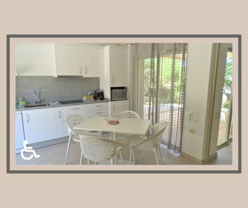 Cuisine-salle à manger moderne à la Résidence Saint Michel B&B à L'île Rousse, Corse, avec électroménager blanc et accès à la terrasse