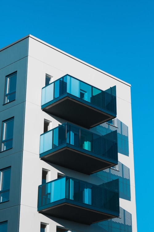 Bâtiment blanc moderne avec balcons en verre bleu au Pavillon M, Grignan