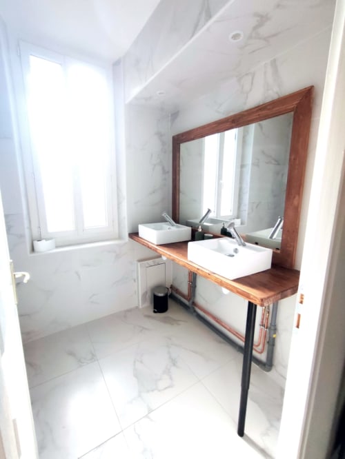 Salle de bain moderne aux Doucesnuits45 à Montargis : murs en marbre, vasques doubles, meuble en bois et grand miroir
