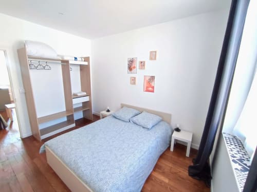 Chambre moderne de Lesdoucesnuits45 à Montargis avec lit queen, armoire en bois, table de nuit et décoration murale