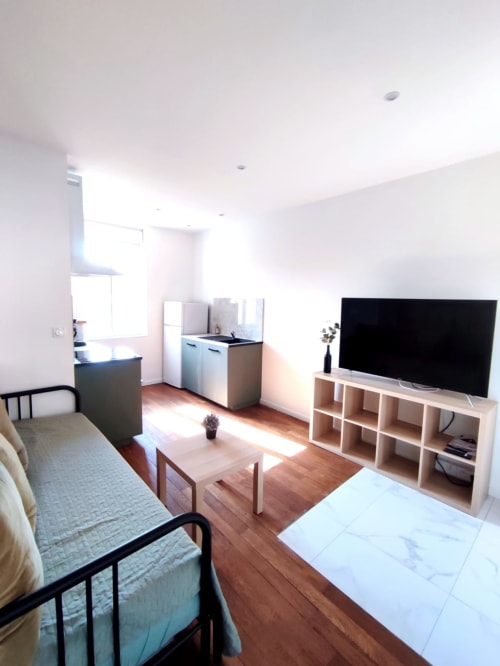 Studio moderne à Montargis avec séjour, kitchenette, lits, TV écran plat et coin repas baigné de lumière naturelle