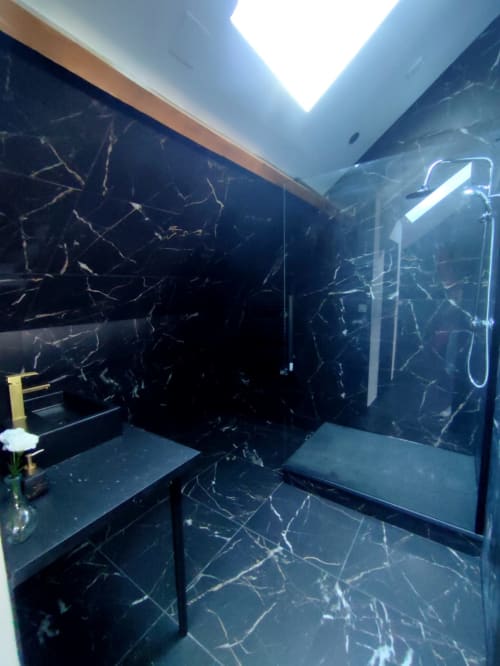 Salle de bain de luxe moderne à Lesdoucesnuits45 à Montargis avec murs en marbre noir, puits de lumière et équipements contemporains