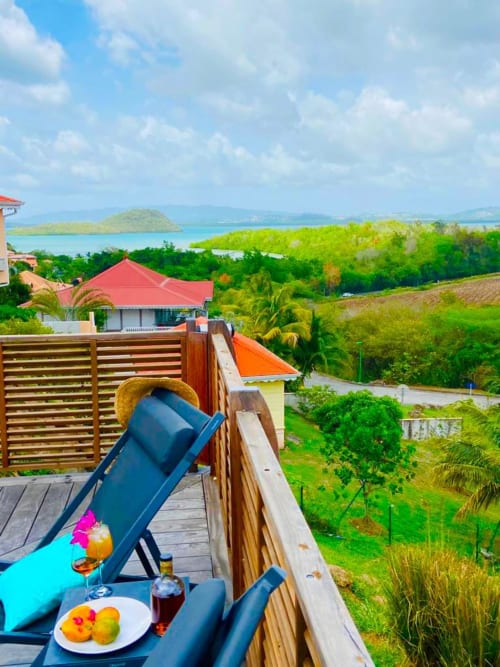 Villa en bord de mer à la Martinique avec vue sur l'océan, transats, cocktails tropicaux et eaux turquoise aux Hébergements