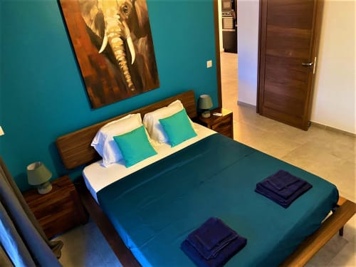 Chambre moderne de la villa Passion Cannelle aux Hébergements Passion, Martinique, avec murs turquoise, lit en bois et