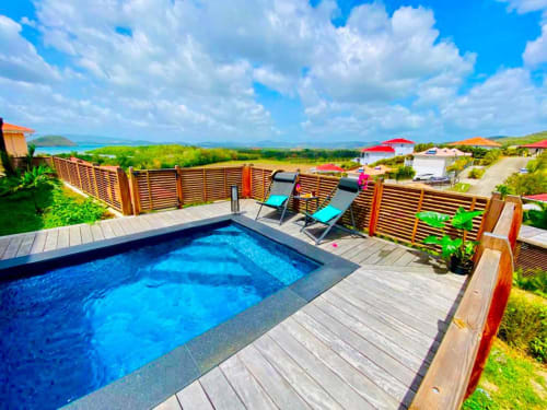Villa avec piscine privée et vue sur mer aux Hébergements Passion, Martinique, terrasse en bois et transats