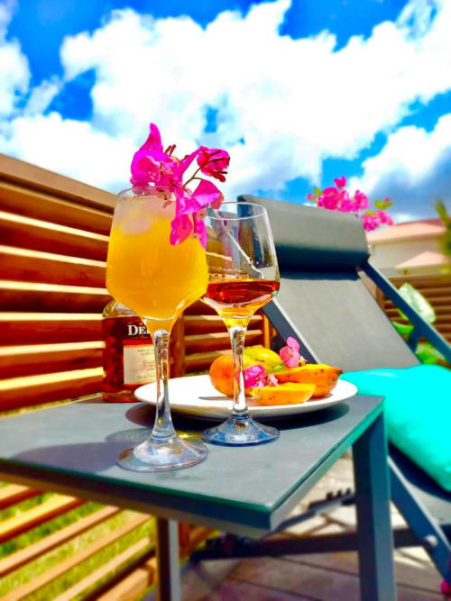Cocktails tropicaux avec fleurs de bougainvillée rose sur la terrasse de la villa Les Hébergements Passion à la Martinique