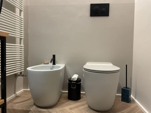 Bagno moderno a Covo del Pirata Venezia con bidet bianco, WC, scaldasalviette e rubinetteria nera