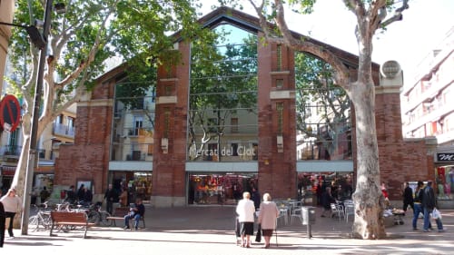 Mercado del Clot Barcelona entrance with brick façade, outdoor seating area, and trees in Plaza del Clot neighborhood
