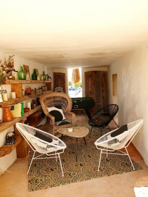 Salon moderne de la villa Las Fincas De Annie avec chaises en fil blanc, meubles tressés et étagères en bois à Felanitx