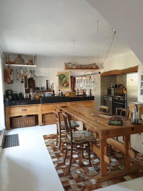 Cuisine et salle à manger rustiques à Felanitx avec mobilier en bois, plans de travail noirs et carrelage traditionnel