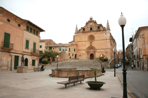 Place de l'église en pierre historique à Felanitx, Espagne avec architecture traditionnelle et bancs