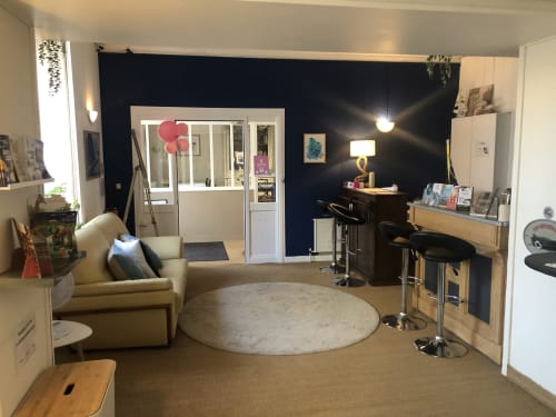 Modern studio apartment at Hôtel Maison Richet in Les Sables-d'Olonne with lounge area, kitchenette, and dark accent wall