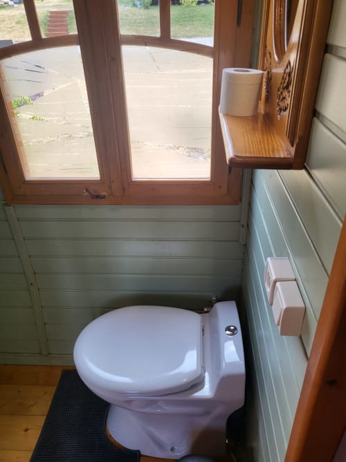 Toilettes blanches dans la salle de bain d'un chalet avec vue sur le jardin à Les Refuges Du Chalet, Jalhay