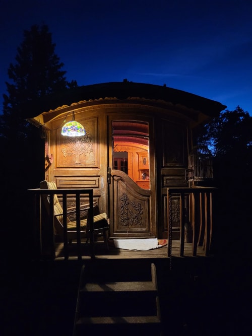 Caravane vintage illuminée aux Refuges Du Chalet à Jalhay, Belgique, vue nocturne du jardin